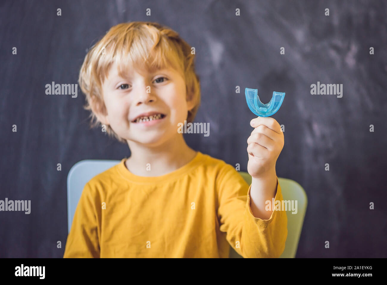 Three-year old boy shows myofunctional trainer. Helps equalize the growing teeth and correct bite, develop mouth breathing habit. Corrects the positio Stock Photo