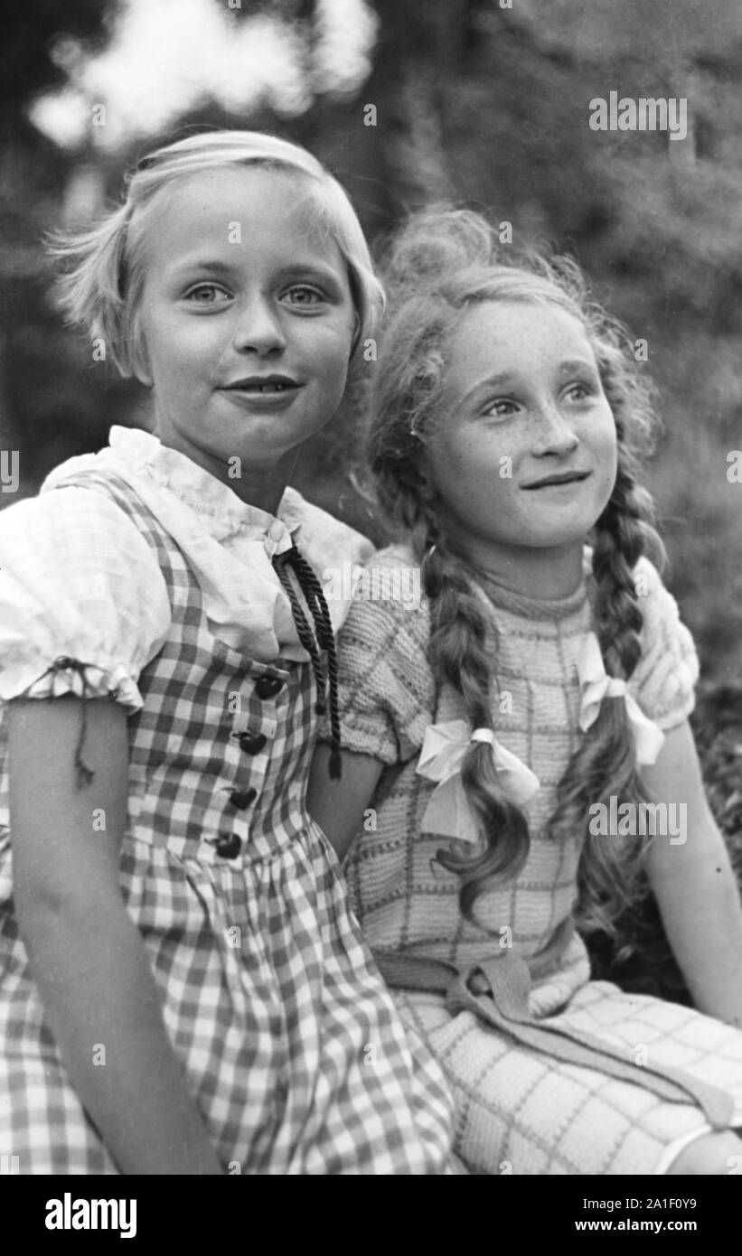 Zwei Mädchen sitzen in einem Garten, Deutschland 1939. Two girls sitting in a garden, Germany 1939. Stock Photo