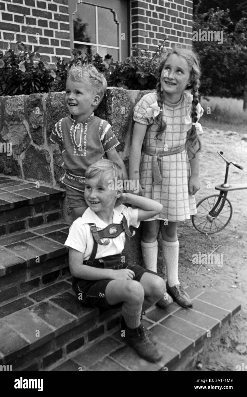 Drei Kinder bei einem Treppchen zum Garten, Deutschland 1939. Three children by a small stairway, Germany 1939. Stock Photo