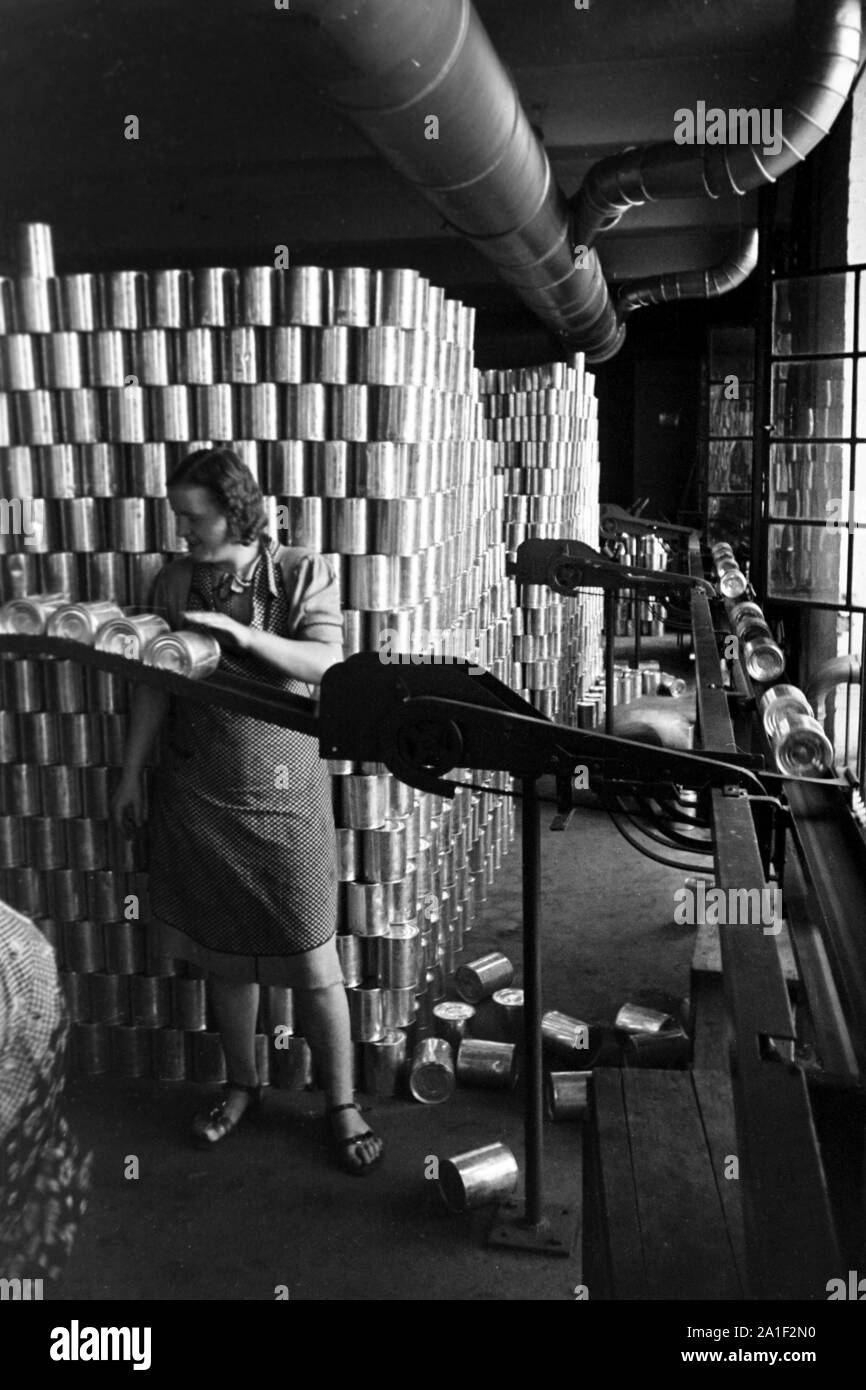 Eine Frau sortiert eingebleute Dosen aus in der Konservenfabrik C. Th. Lampe in Braunschweig, Deutschland 1939. A woman sorting out defect tin cans of the canning factory C. Th. Lampe in Brunswick, Germany 1939. Stock Photo