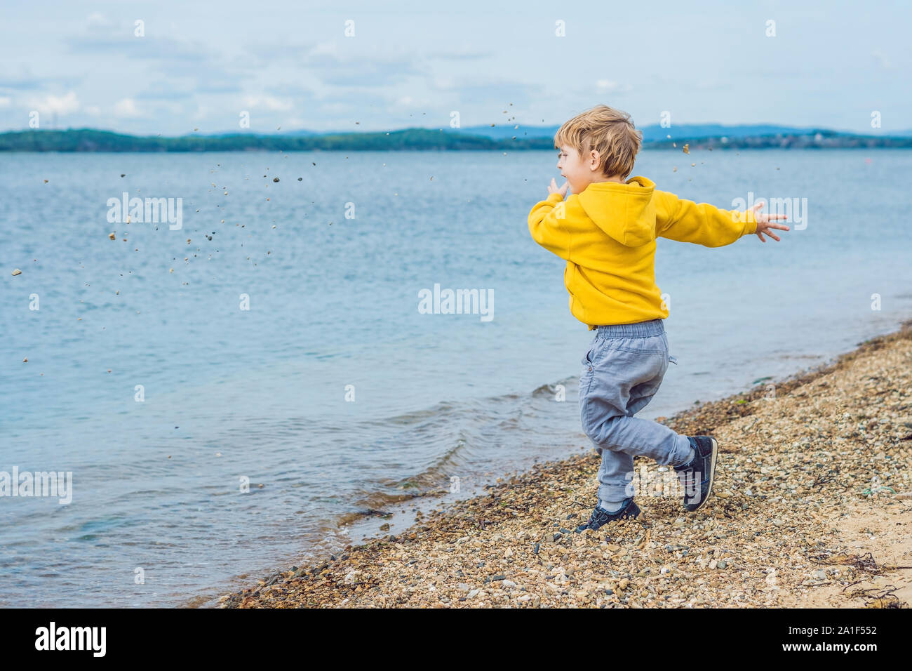 мальчик в камешках. мальчик в камешках. мальчик бросает камни в речку. подростки кидают камни. камень для детей.