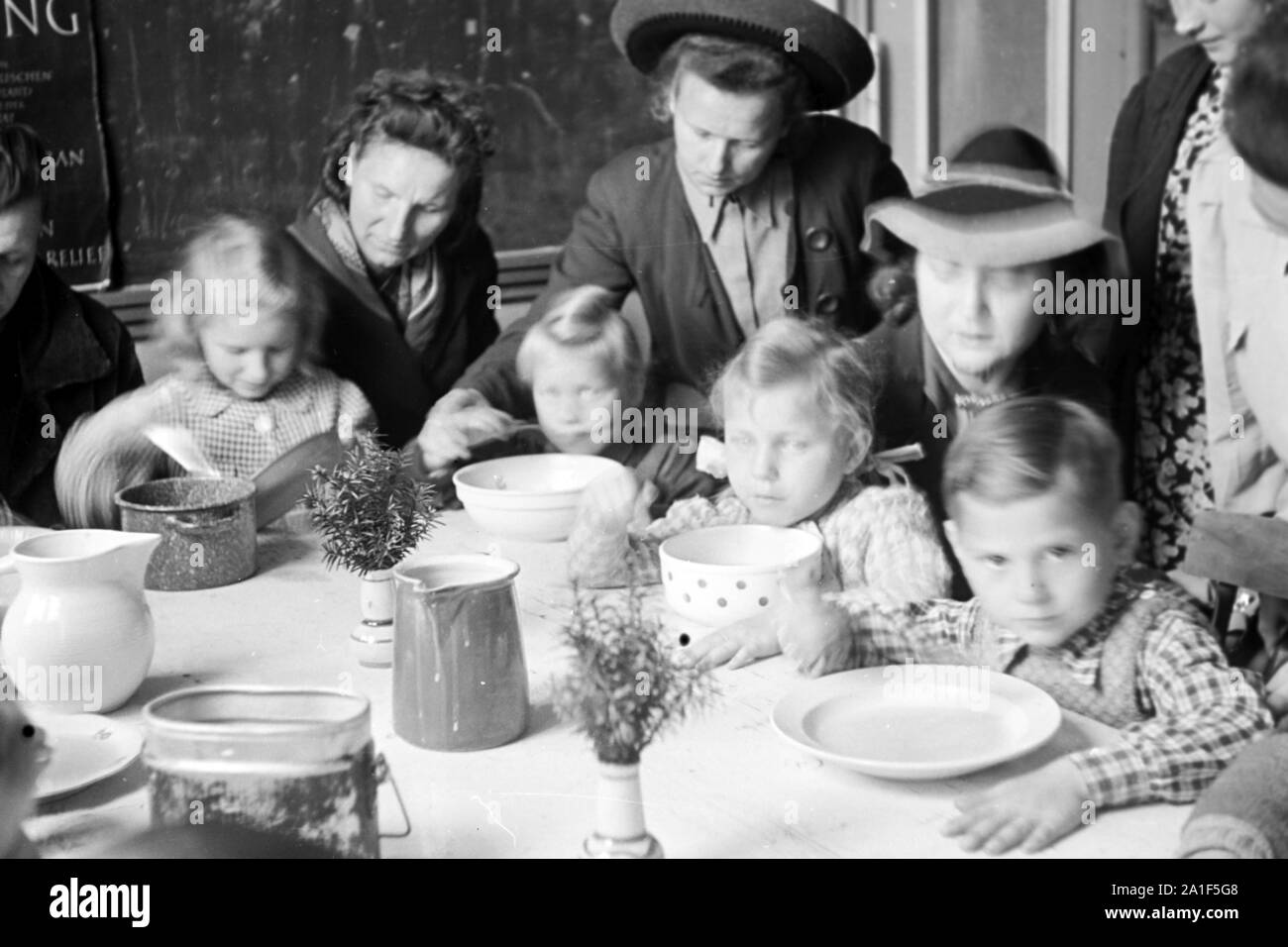 Kinder bekommen die Speisung durch die Canadian Lutheran World Relief in einer karitativen Einrichtung in Frankfurt an der Oder, Deutschland 1948. Children get the feeding sponsored by the Canadian Lutheran World Relief at a charity station in Frankfurt / Oder, Germany 1948. Stock Photo