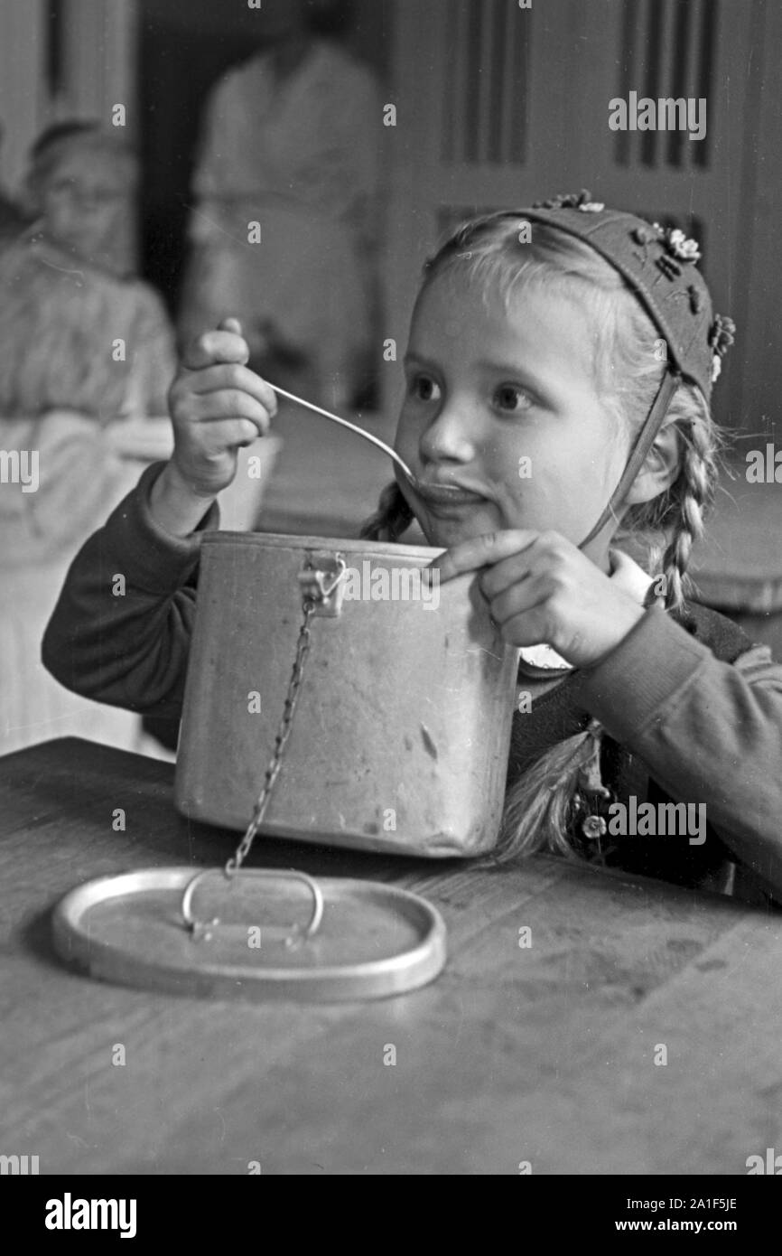 Ein Mädchen bei der Speisung durch die Canadian Lutheran World Relief in einer karitativen Einrichtung in Frankfurt an der Oder, Deutschland 1948. A girl gets the feeding sponsored by the Canadian Lutheran World Relief at a charity station in Frankfurt / Oder, Germany 1948. Stock Photo