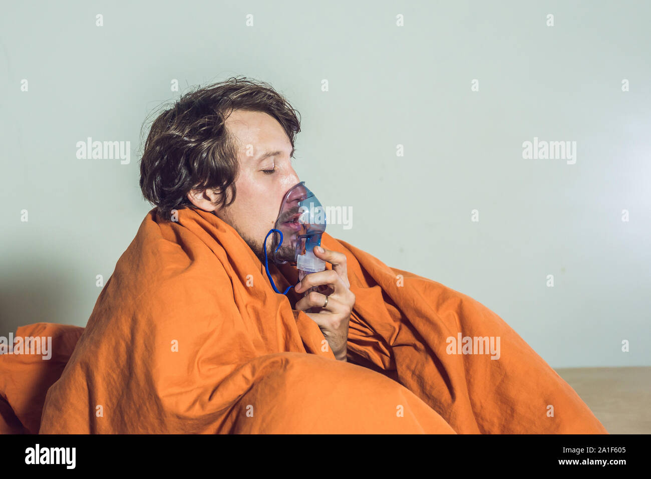 man with flu or cold symptoms making inhalation with nebulizer