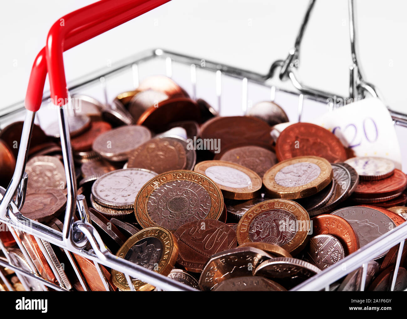 Shopping basket filled with coins Stock Photo