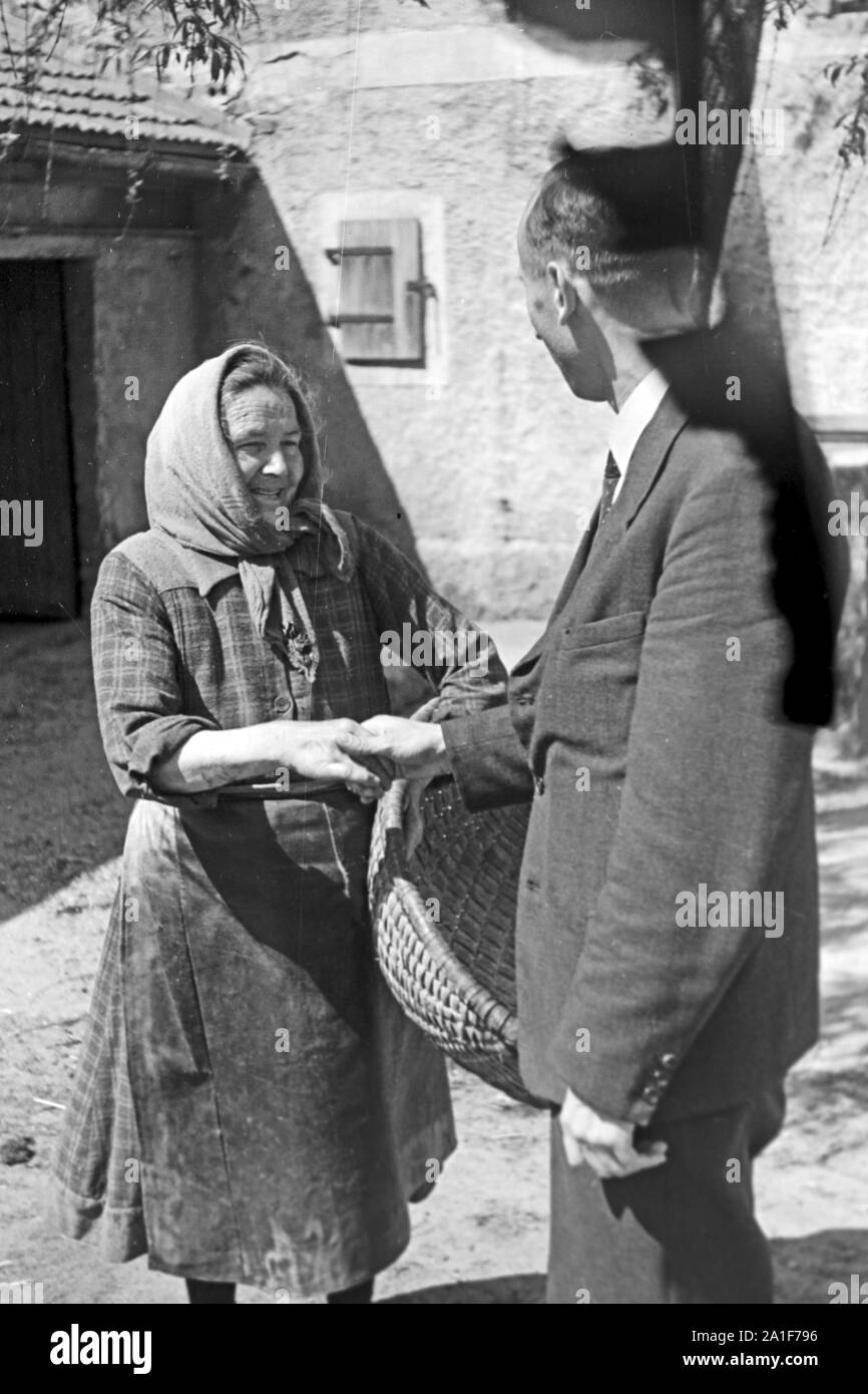 Pfarrer Egon Vögler trifft Menschen aus der Gemeinde Horka, Deutschland 1949. Priest Egon Voegler meeting and talking to a member of his parish Horka, Germany 1949, Stock Photo