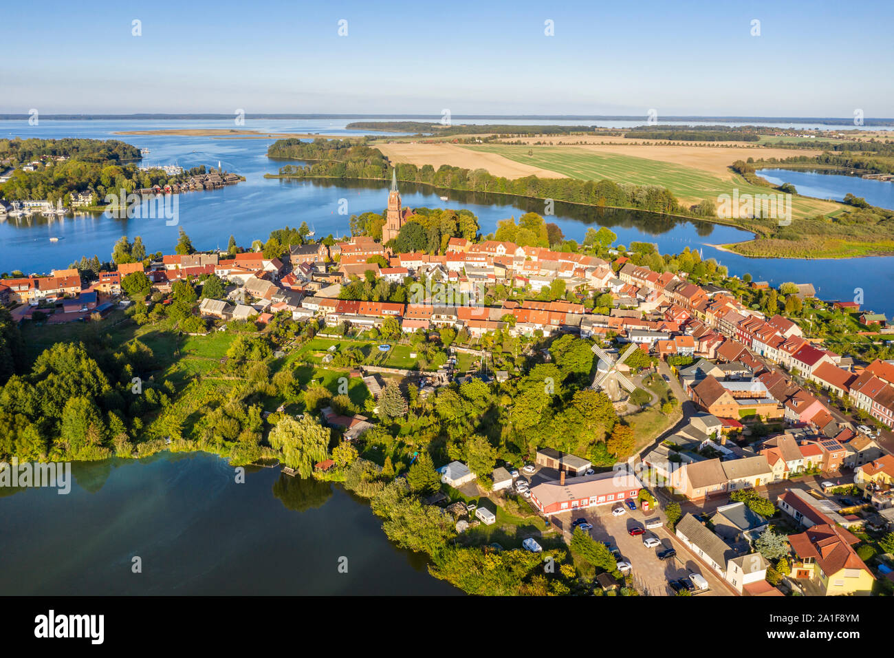 Drone shot, aerial view over town of Röbel, lake Mönchteich in front, St. Mary's Church in center,  lake Mueritz,  Mecklenburg-Vorpommern, Germany Stock Photo