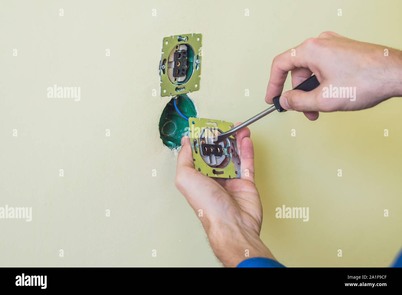 Electrician Installing Socket In New House. Electrician in the house Stock Photo