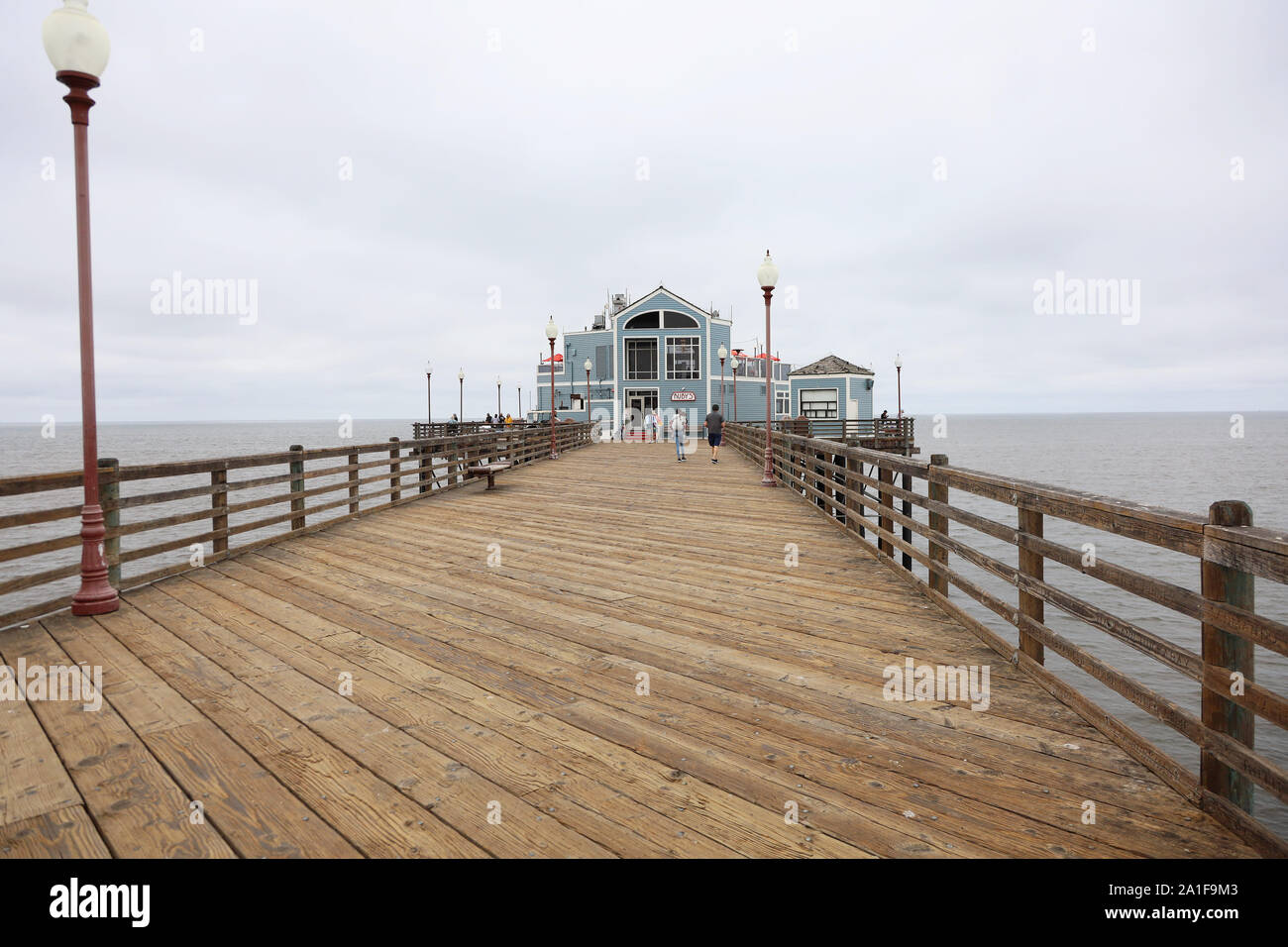 Vintage toned image of fishing pole on the dock at California pier with  beach and ocean Stock Photo - Alamy