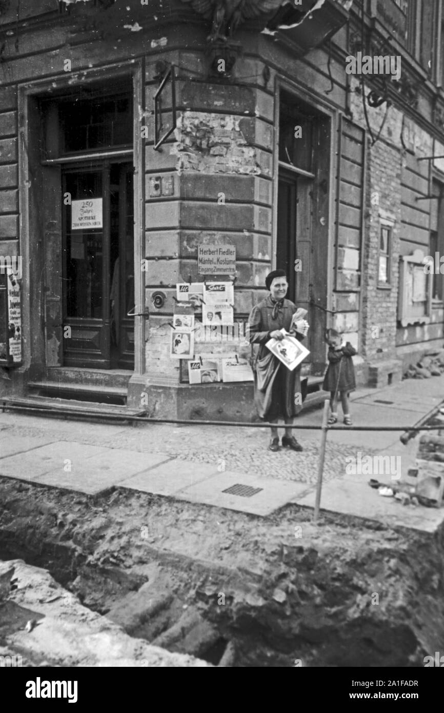 Eine Frau verteilt Flugblätter an der Ecke Wilhemstraße und Zimmerstraße in Berlin, Deutschland 1946. A woman giving away flyers at the corner of Wilhelmstrasse and Zimmerstrasse at Berlin, Germany 1946. Stock Photo