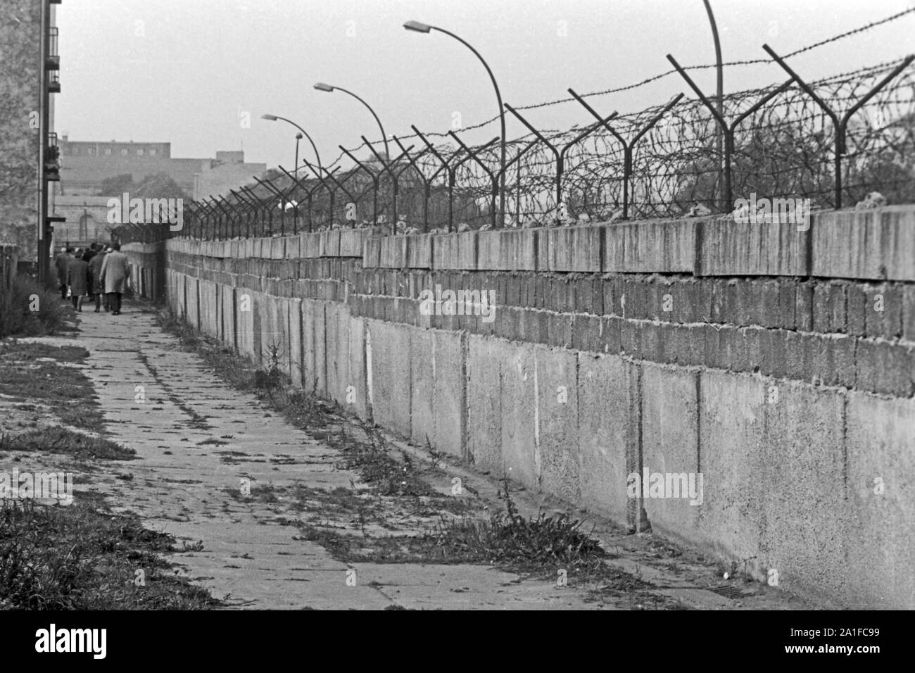 Menschen gehen auf der Westseite an der Mauer in Berlin entlang, Deutschland 1962. People taking a walk by the Berlin wall, Germany 1962. Stock Photo