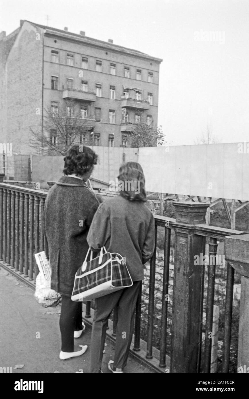 Zwei Frauen stehen vor einem Sichtschutz an der Grenze des amerikanischen Sektors in Berlin, Deutschland 1962. Two women are standing in front of a blind at the border of the American sector in Berlin, Germany 1962. Stock Photo