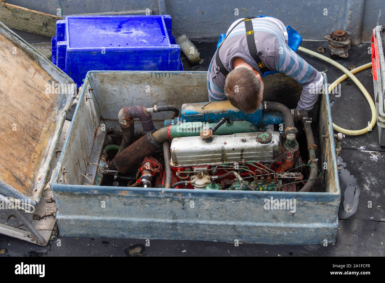 man working on his fishing boat engine Stock Photo