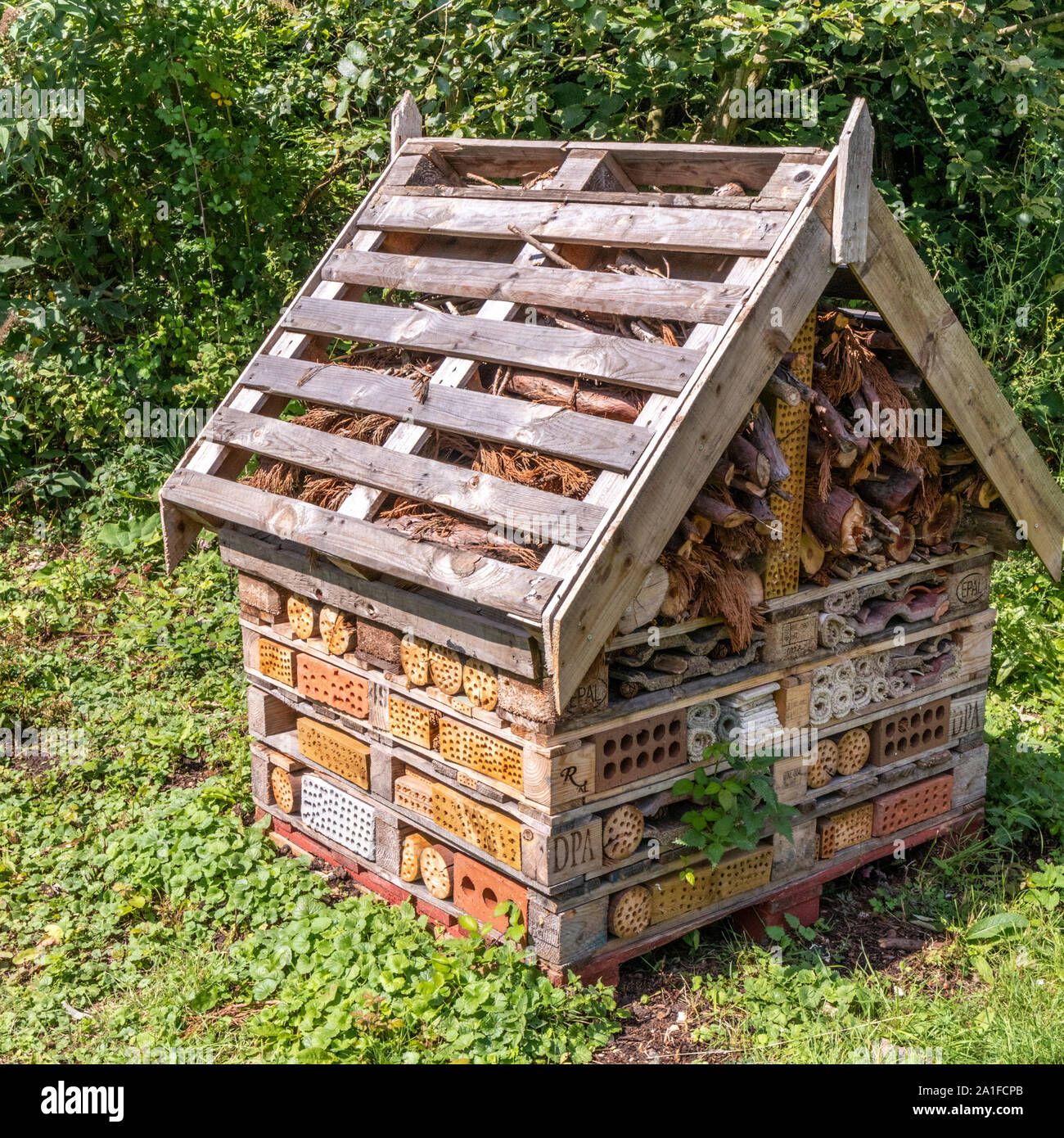 A multi faceted bug hotel in the grounds of Nature in Art museum and art gallery at Wallsworth Hall, Twigworth, Gloucestershire UK Stock Photo