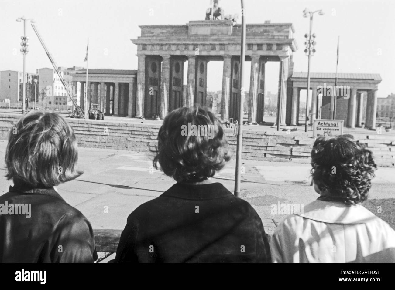 Touristen schauen auf das abgetrennte Brandenburger Tor in Berlin, Deutschland 1962. Tourists having a view to the separated Brandenburg gate at Berlin, Germany 1962. Stock Photo