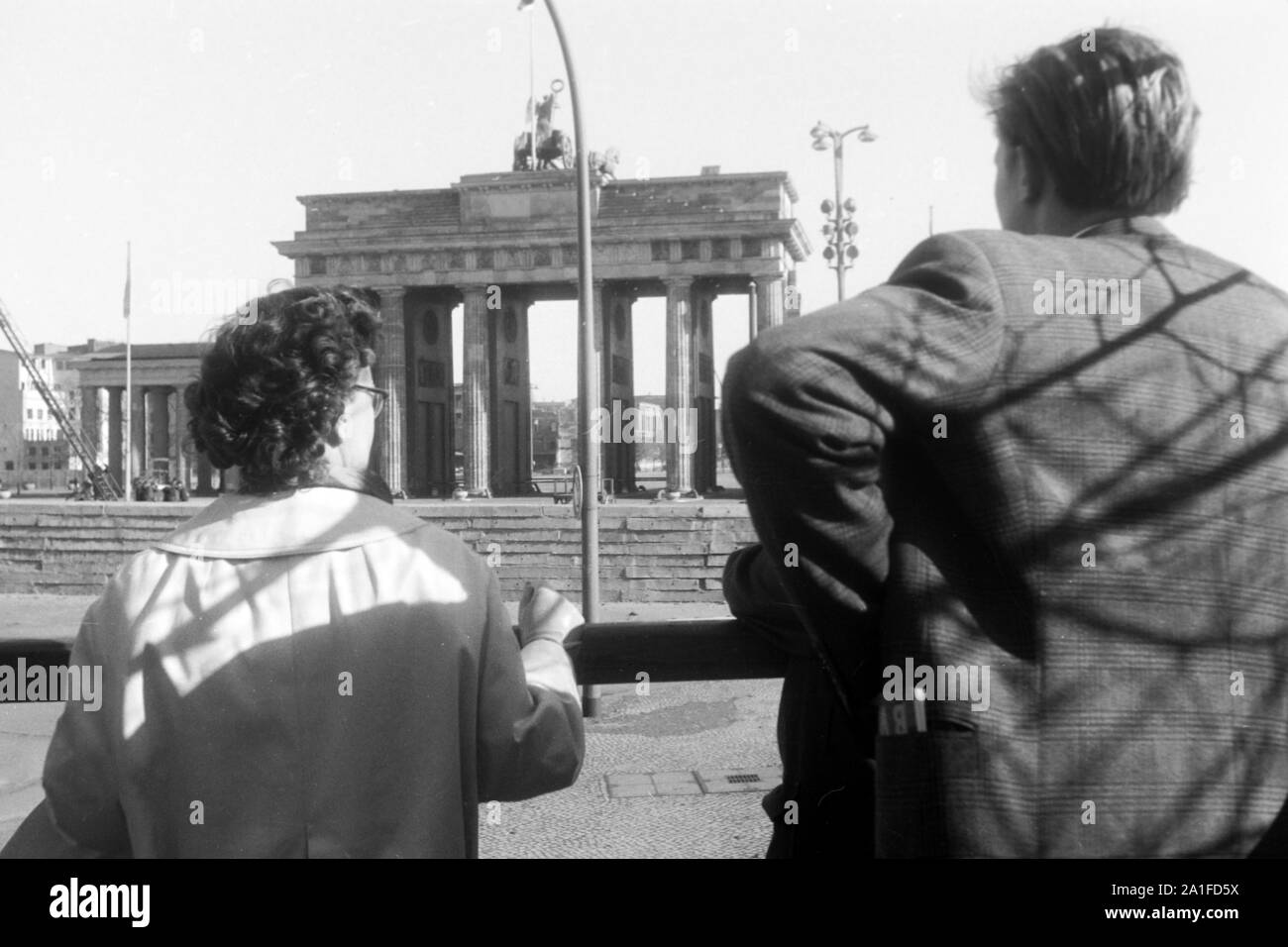 Touristen schauen auf das abgetrennte Brandenburger Tor in Berlin, Deutschland 1962. Tourists having a view to the separated Brandenburg gate at Berlin, Germany 1962. Stock Photo