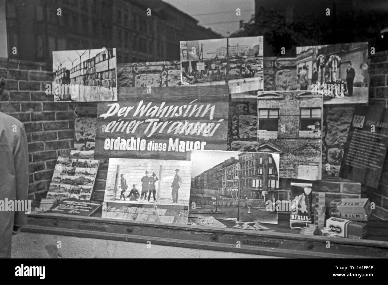 Schaufensterdekoration 'Der Wahnsinn einer Tyrannei erdachte diese Mauer' in einem Souvenirladen in Berlin, Deutschland 1962. Shop window decoration at a souvenir shop in Berlin, Germany 1962. Stock Photo