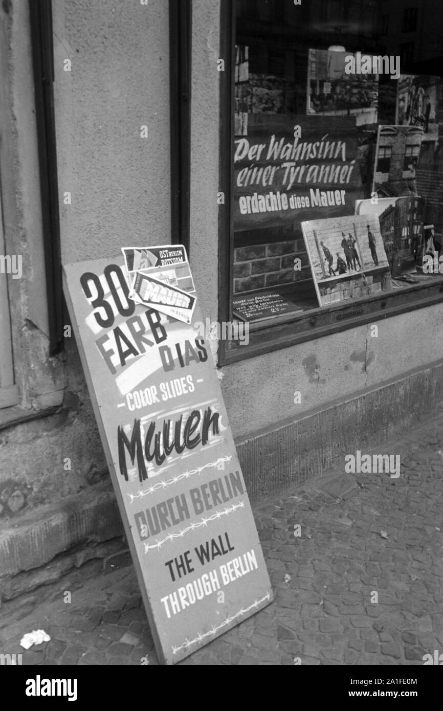 Schaufensterdekoration 'Der Wahnsinn einer Tyrannei erdachte diese Mauer' in einem Souvenirladen in Berlin, Deutschland 1962. Shop window decoration at a souvenir shop in Berlin, Germany 1962. Stock Photo