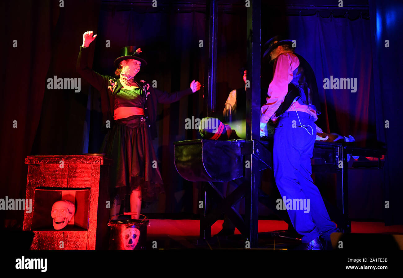 Munich, Germany. 26th Sep, 2019. Carmen, the Schichtelin (l) Luke the Executioner's Servant (m) and Ringo the Executioner (r) stand in the tent of the Schichtl with the guillotine with their sacrifice. on stage on the Wiesn The largest folk festival in the world lasts until 6 October. Credit: Felix Hörhager/dpa/Alamy Live News Stock Photo