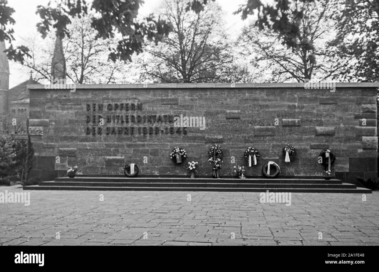 Gedenkstätte für die Opfer der Hitlerdiktatur der Jahre 1933 bis 1945 auf einem Friedhof in Berlin, Deutschland 1962. Memorial wall for the victims of Hitler's dictatorship between 1933 an 1945 in a Berlin cemetery, Germany 1962. Stock Photo