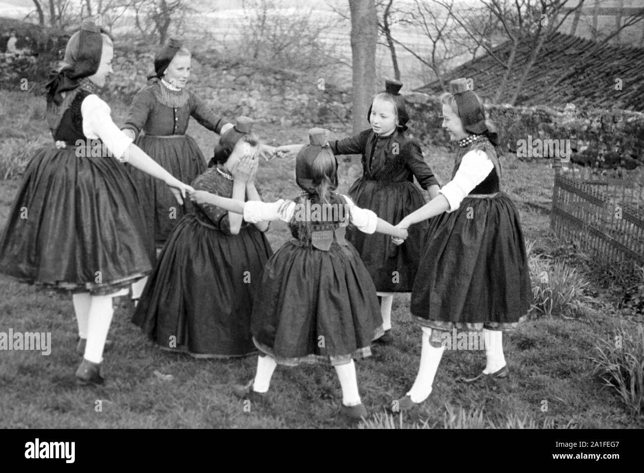 Traditionell tanzende Mädchen der Dorfjugend in Trachten der Schwalm bei Holzburg während eines Häschenspiel (Hasenspiel), gewählt von Edward Steichen für die  MoMa Wanderaustellung von 1955 (The Family of Man), Deutschland 1938. Traditionally dancing girls of the village youth in traditional costumes on the Schwalm near Holzburg during a bunny game (Hasenspiel), chosen by Edward Steichen for the MoMa travelling exhibition of 1955 (The Family of Man), Germany 1938. Stock Photo