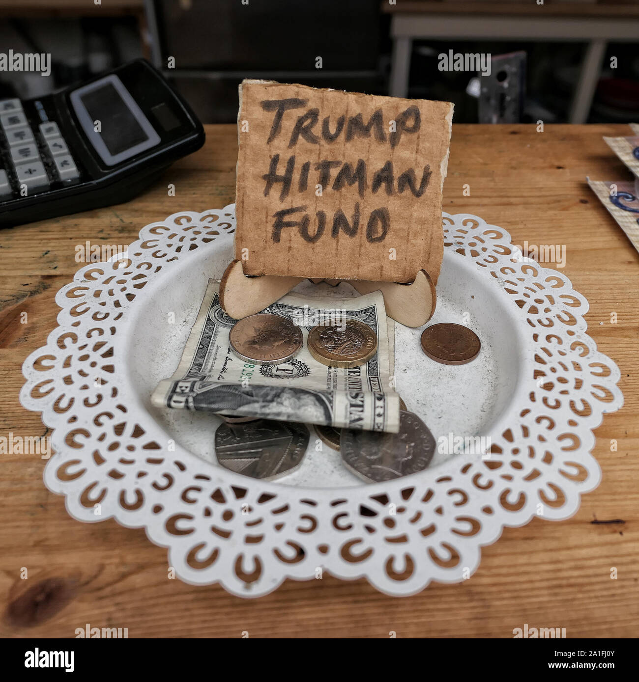 A tips bowl in a cafe with a sign “Trump Hitman Fund” Stock Photo