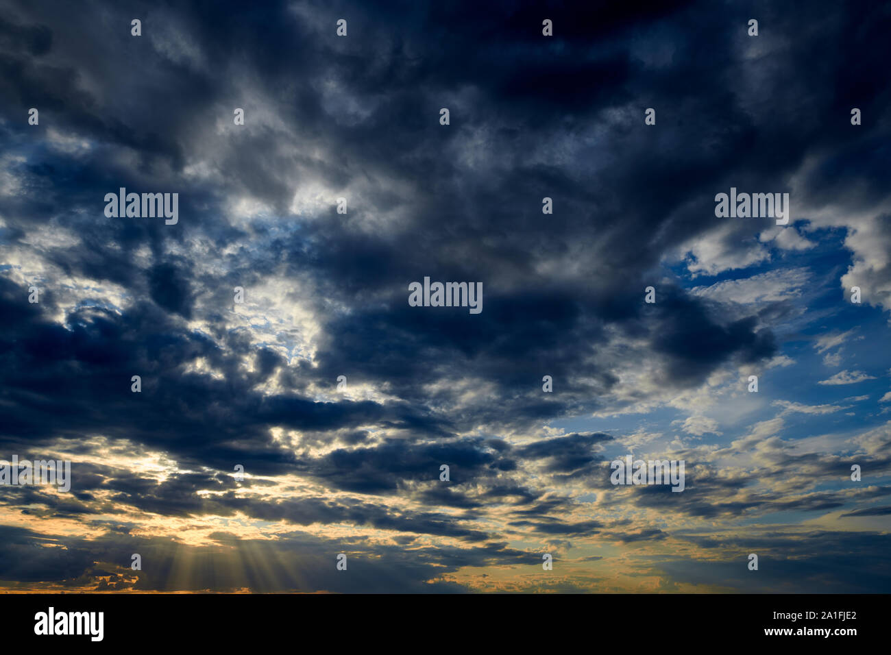 Beautiful sunset - dark sky with clouds and sunlight Stock Photo - Alamy
