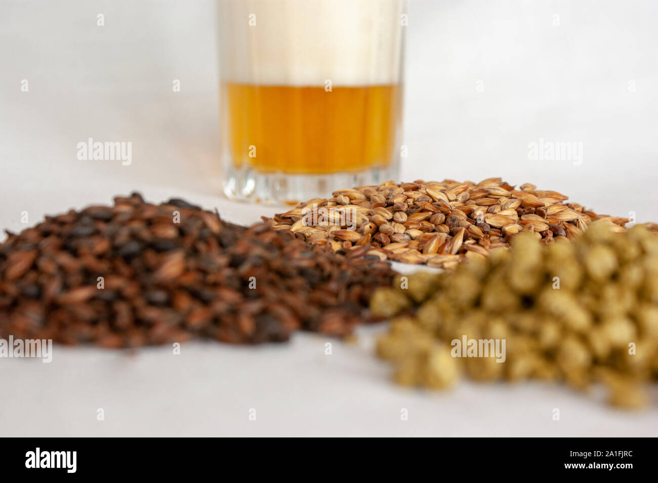 an amber lager pale ale beer and its component over a withe background