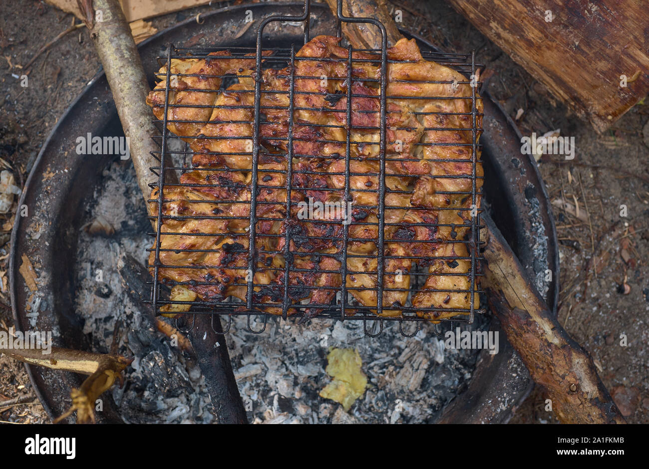 Grilling marinated shashlik preparing on a barbecue grill over charcoal.  Shashlik is a form of Shish kebab popular in Eastern Europe. Shashlyk (meaning  skewered meat) was originally made of lamb. Stock Photo