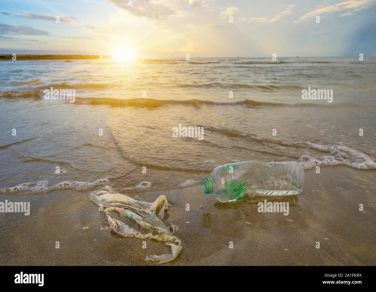 garbage the beach sea plastic bottle lies on the beach and pollutes the sea and the life of marine life Spilled garbage on the beach of the big city. Stock Photo