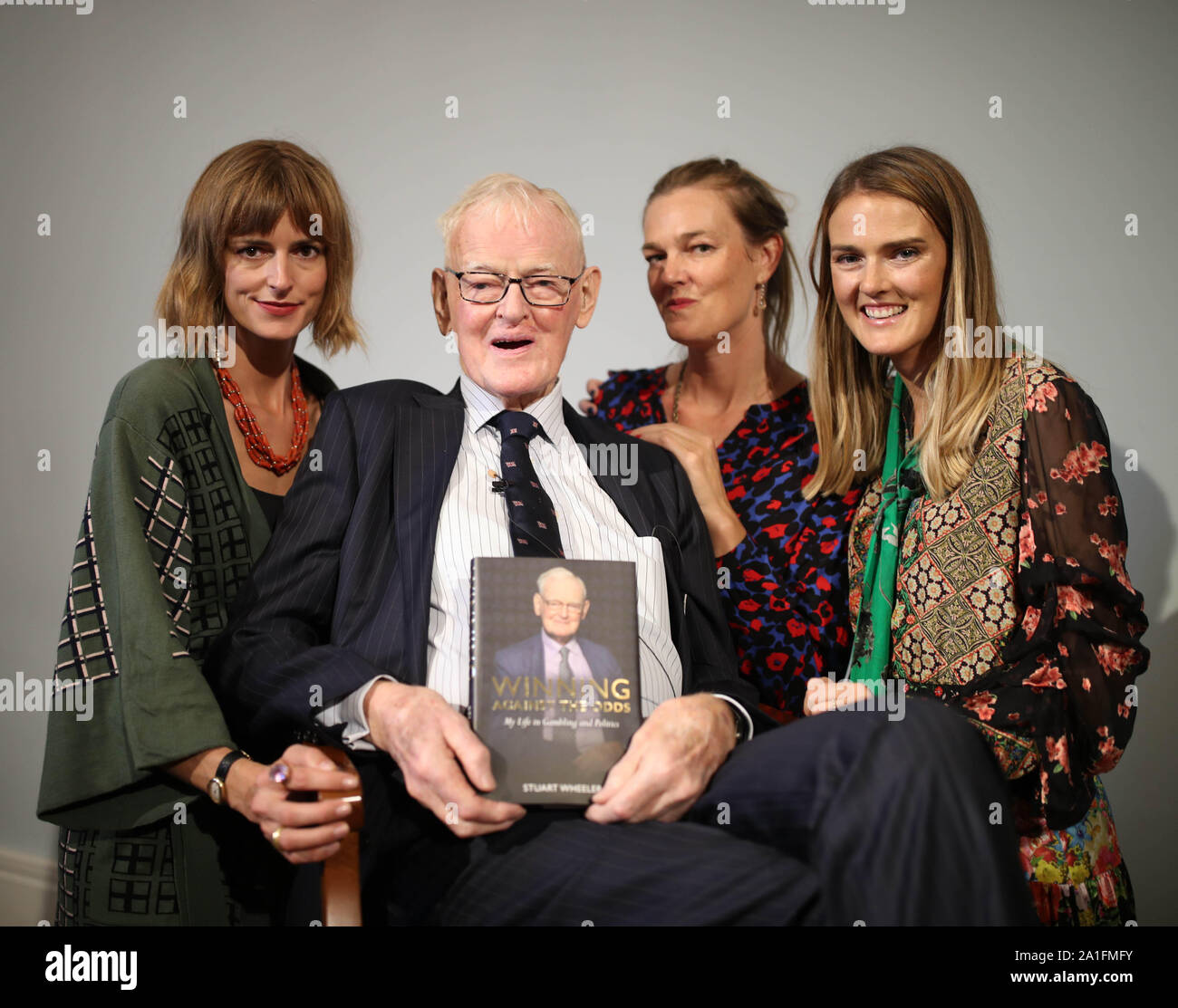 Stuart Wheeler, holding his book, and his three daughters, model Jacquetta Wheeler, 37 (left), Sarah Wheeler (centre) and Charlotte Wheeler (right) at the book launch of My Life in Gambling and Politics by Stuart Wheeler at Carlton House Terrace, London. Stock Photo