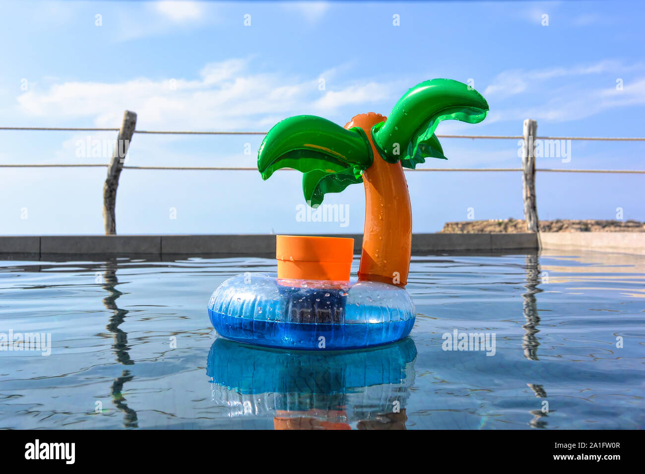 Inflatable palm tree, tropical drinks holder in a swimming pool Stock Photo