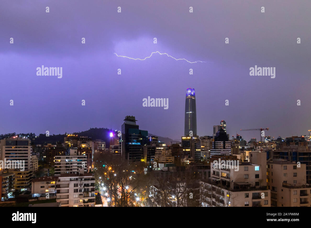 Dramatic view of Santiago de Chile under the rays from an electrical thunderstorm impacting the ground, amazing lines coming from the sky to the Earth Stock Photo