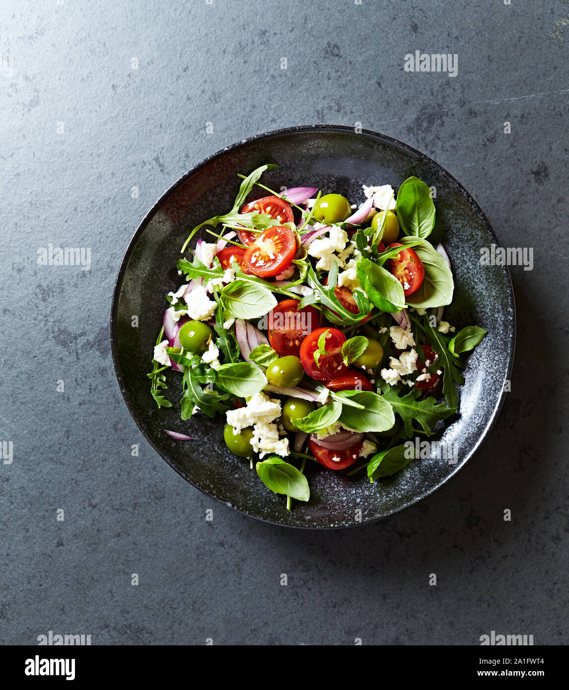 Greek Salad with Cucumeber, Kalamata Olives, Feta Cheese, Cherry Tomatoes, Red Onion and Fresh Basil. Stock Photo
