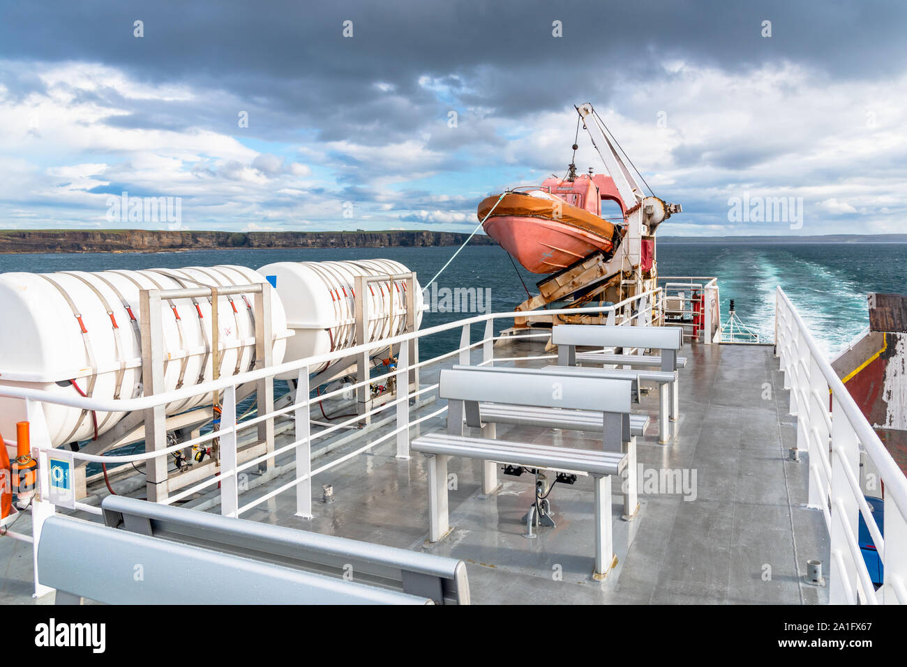 Deserted upper deck of a ferry boat in navigation with a lifeboat and other safety equipment Stock Photo