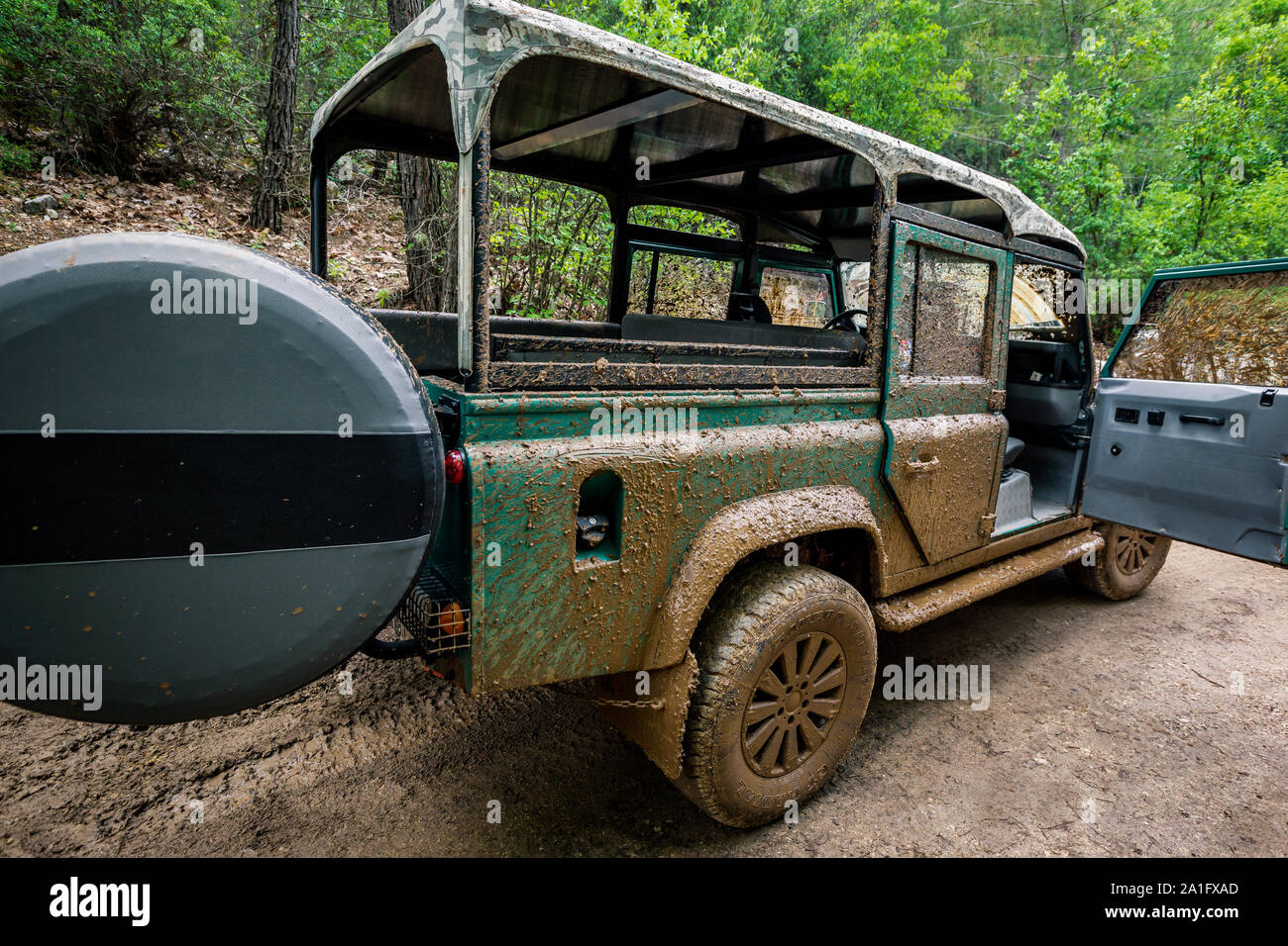 Dirty Four wheel drive truck 4x4 with all terrain tires parked in the forest Stock Photo