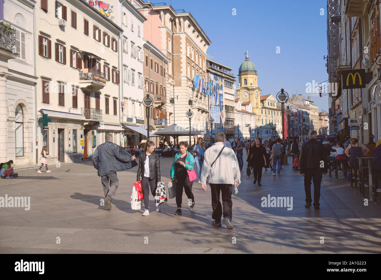 Crowd walking on Korzo, Rijeka's main pedestrian street lined with cafes and shops on sunny spring day Stock Photo