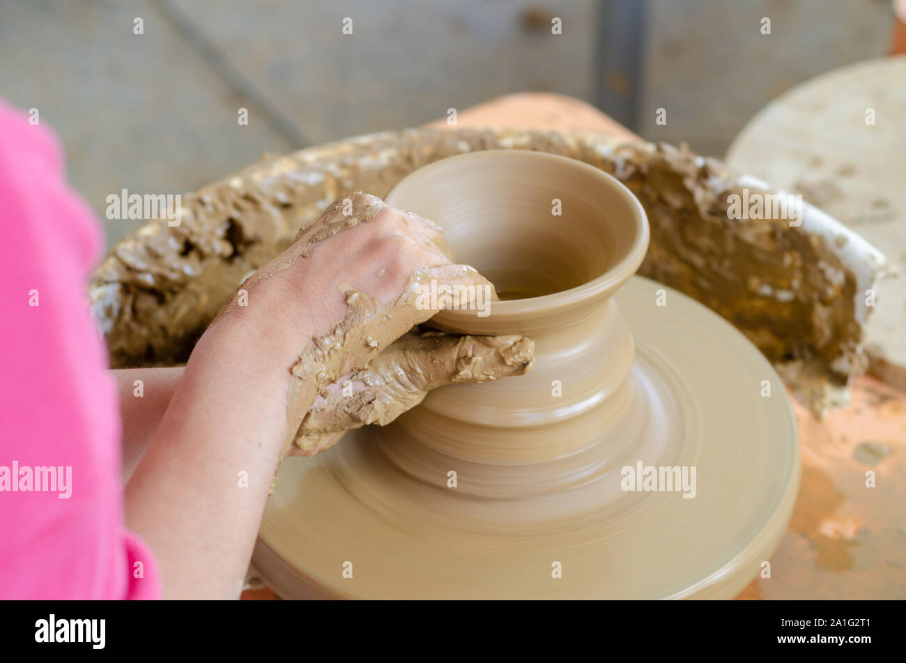 Ceramic working process with clay potter's wheel, top view. The woman