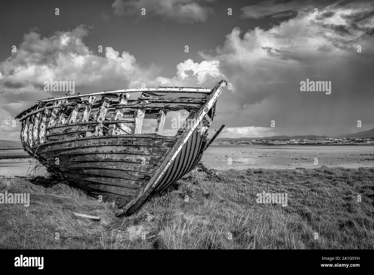 An old wooden Fishing boat decaying on a beach in Donegal Ireland Stock Photo