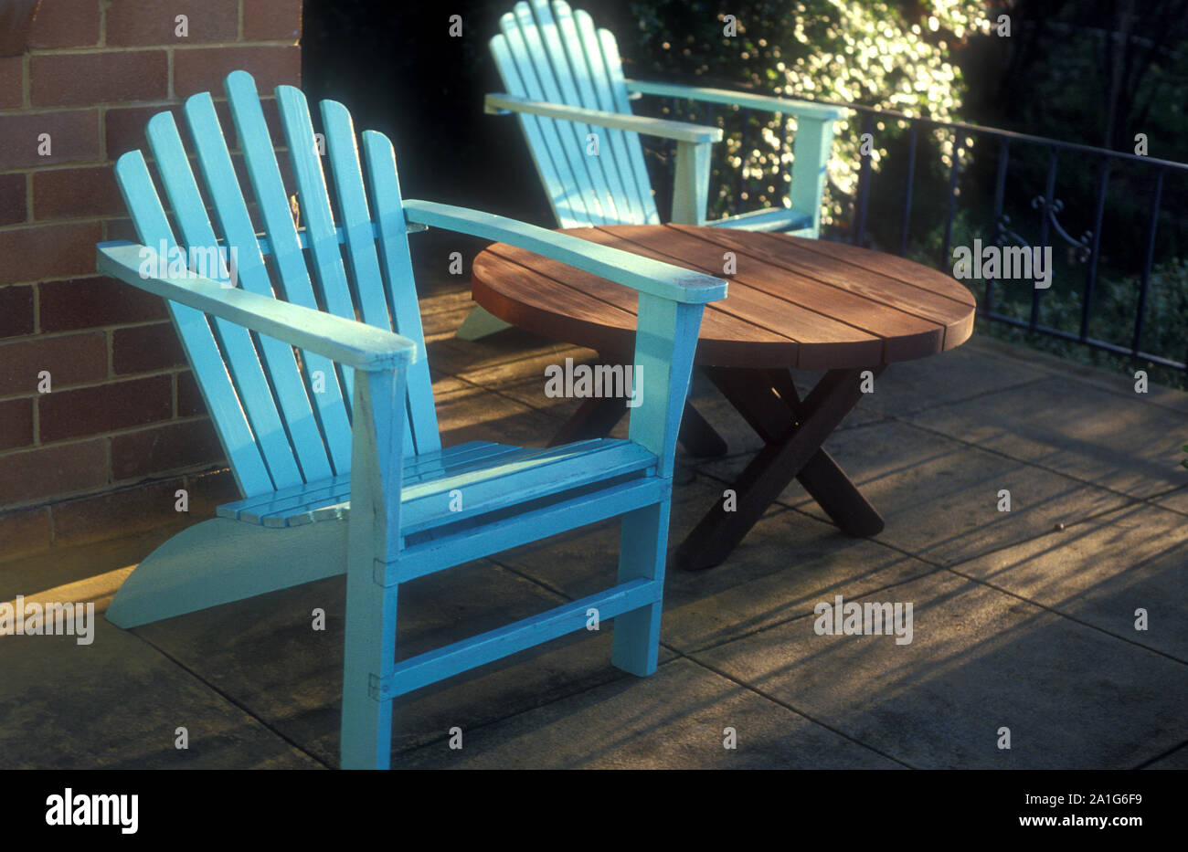 Two Cape Cod Style Outdoor Chairs And Circular Wooden Table Stock