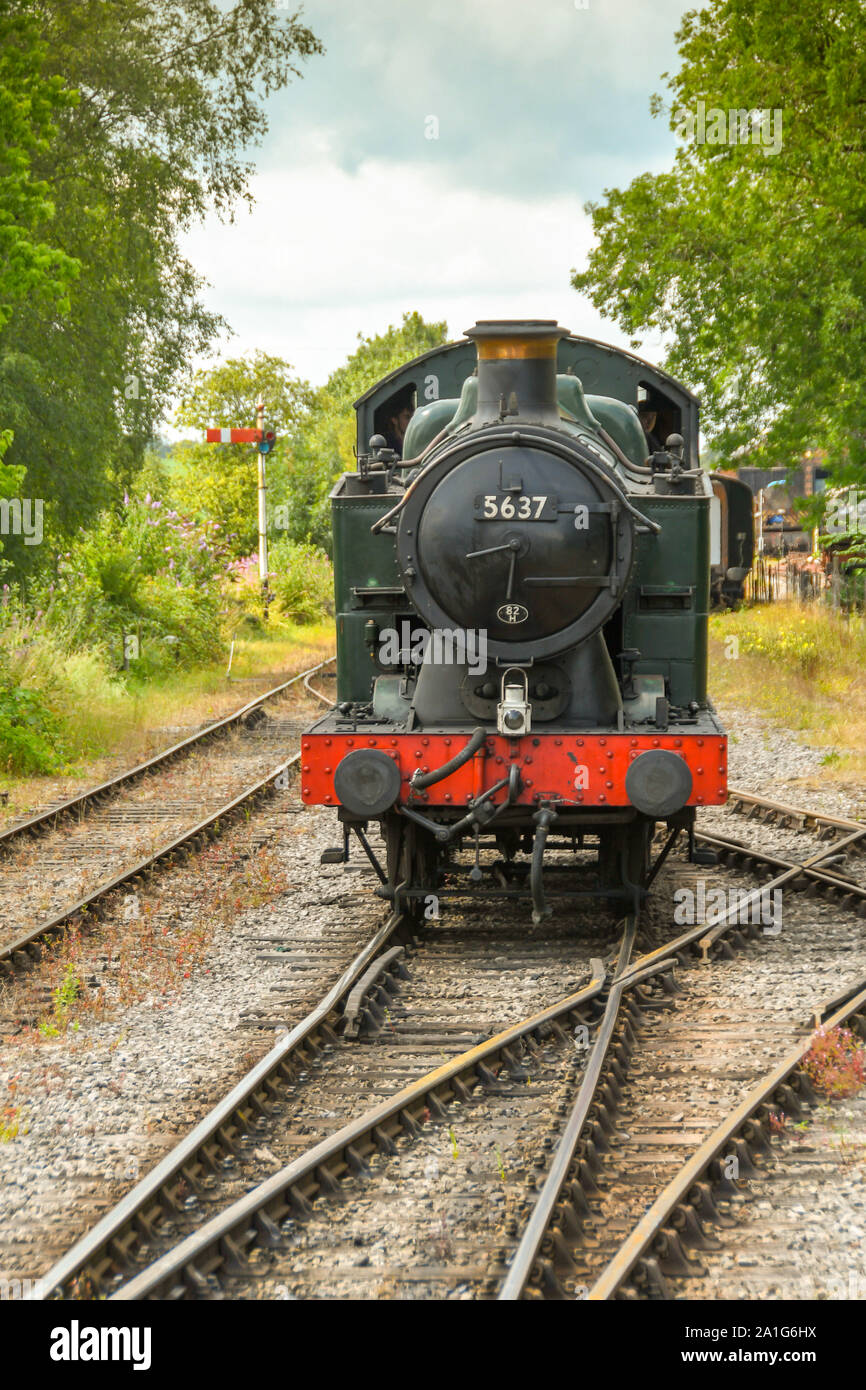 CRANMORE, ENGLAND - JULY 2019: Head on view of a restored steam engine approaching Cranmore Station on the East Somerset Railway. Stock Photo