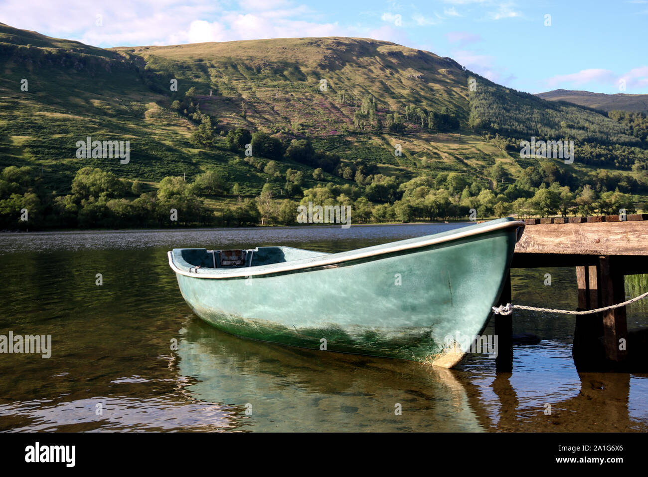 Rowing boat tied up at a Scottish loch jetty Stock Photo - Alamy