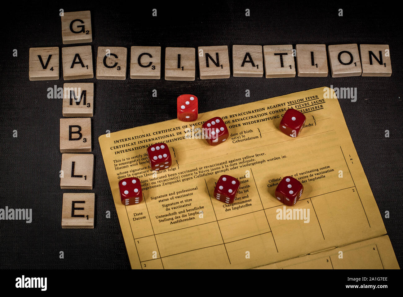 Gambling your health by not getting vaccination shots versus immunity with the words vaccination andd gamble spelled out in scrabble letters Stock Photo