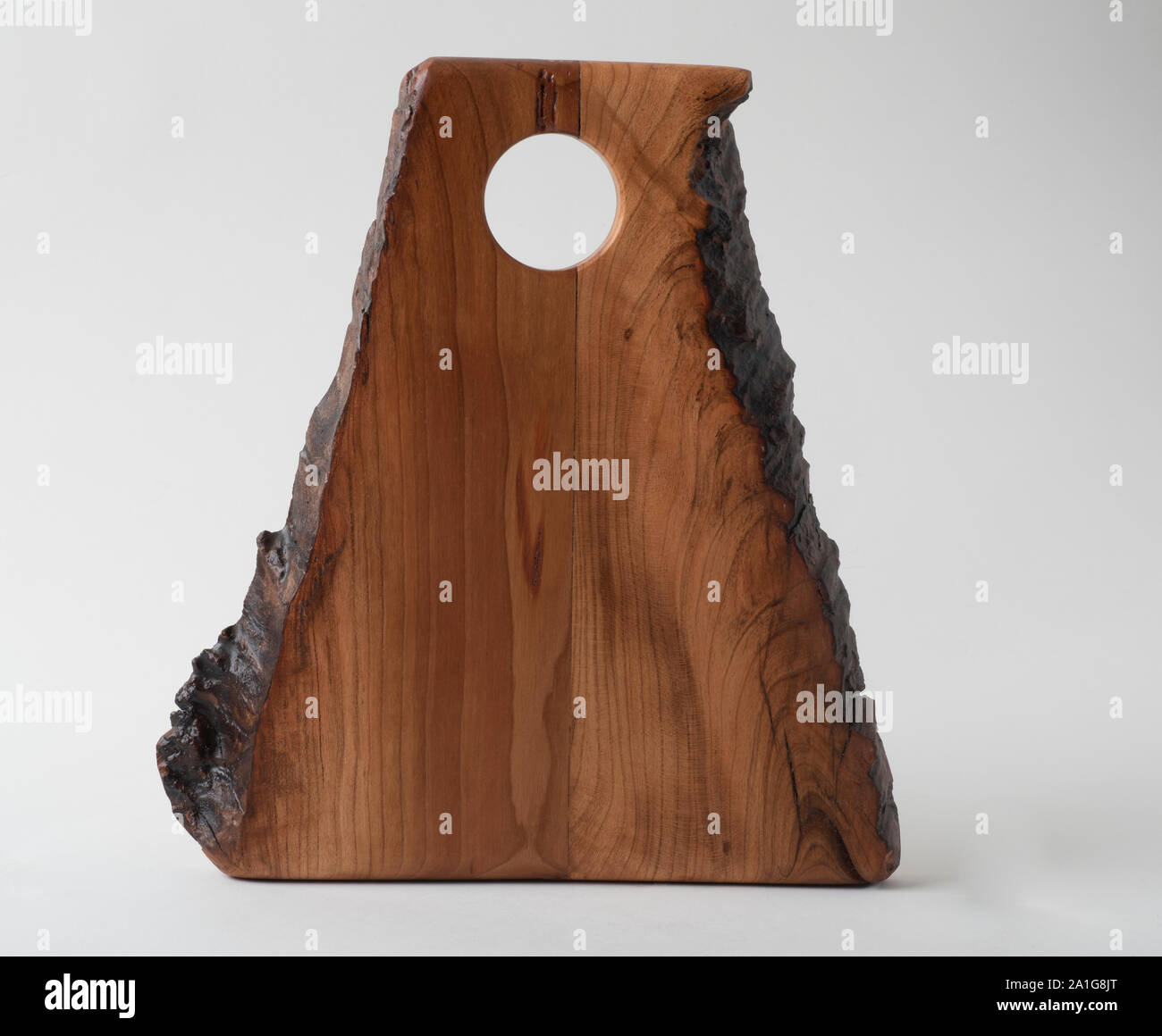 Small Handmade Cutting Or Charcuterie Board Made From Cherry Wood With Live Edge On Two Sides And A Grasp Or Hanging Hole At The Top Also Functions Stock Photo Alamy