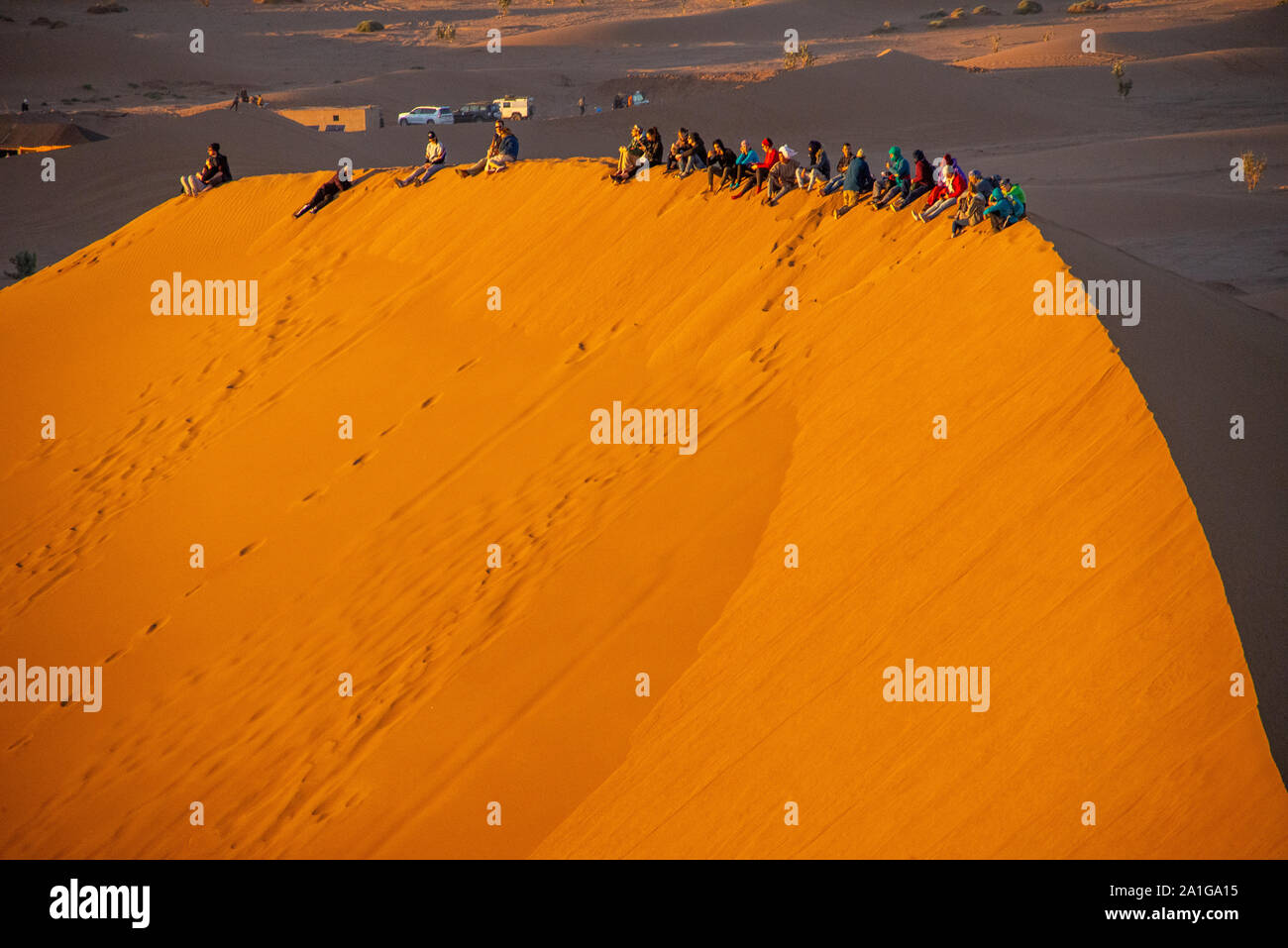 people on sand dunes in sunset at desert of Morocco Stock Photo