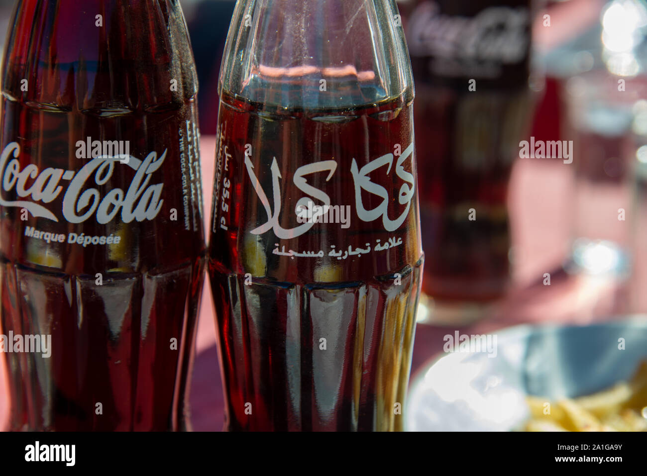 two bottles of cola, one arabic and one English Stock Photo