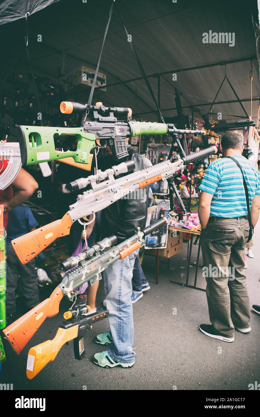 Guns for child in street shop during city celebration Stock Photo