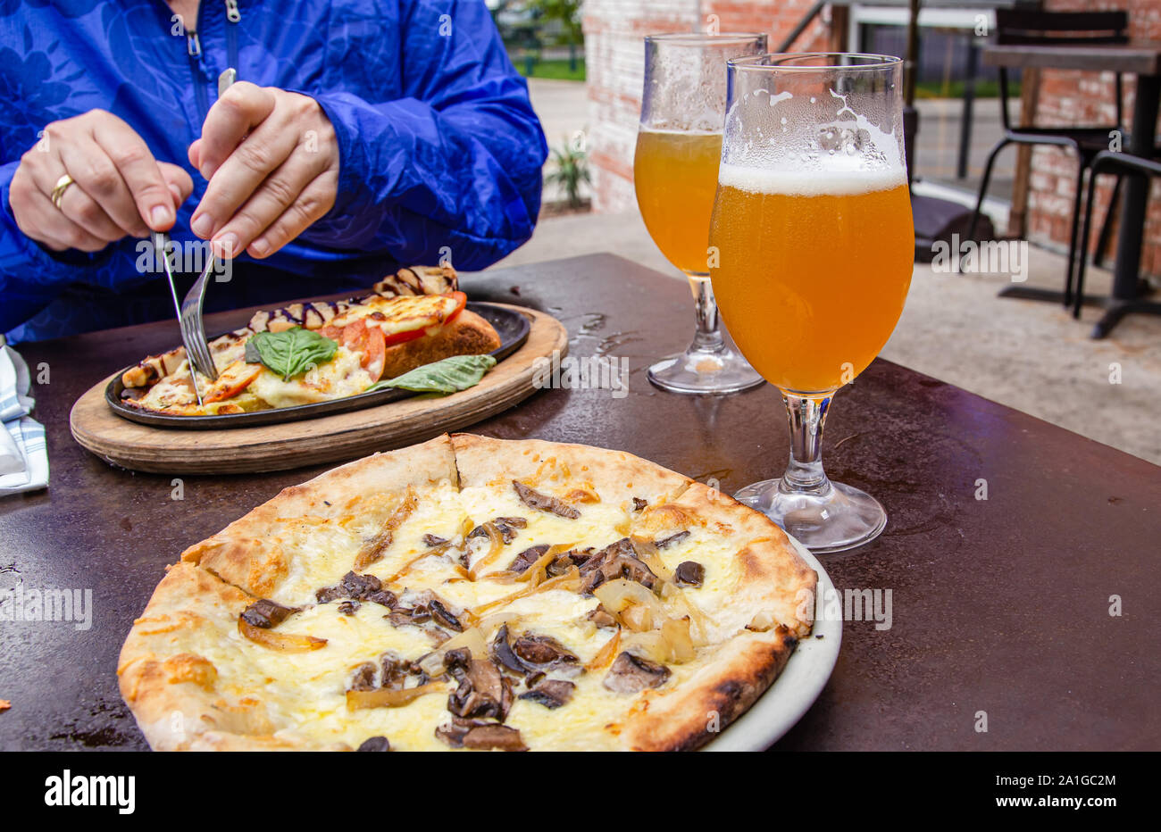 Pizza, beers and chicken sandwich ay outdoor brewpub Stock Photo