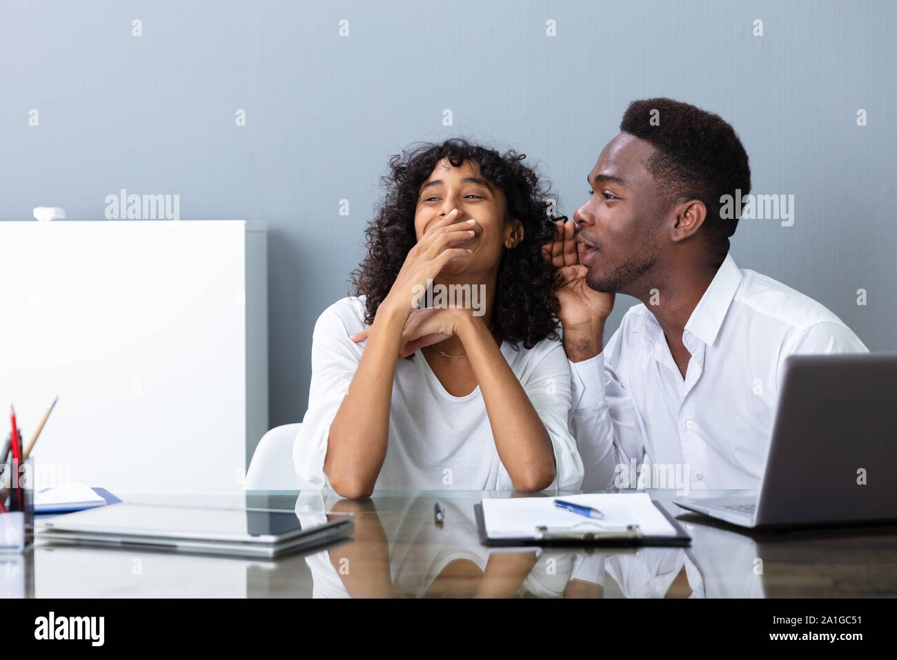 People Laughing About Their Coworker In Office Stock Photo