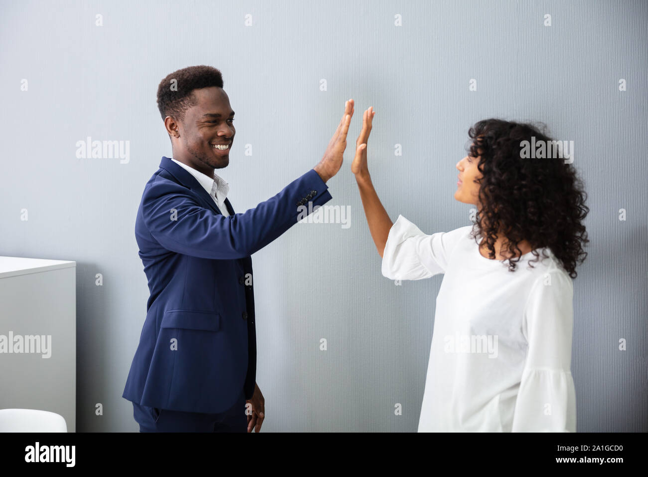 Businessman Giving High Five To His Colleague At Work Stock Photo